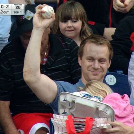 Fan grabs foul ball while holding his child