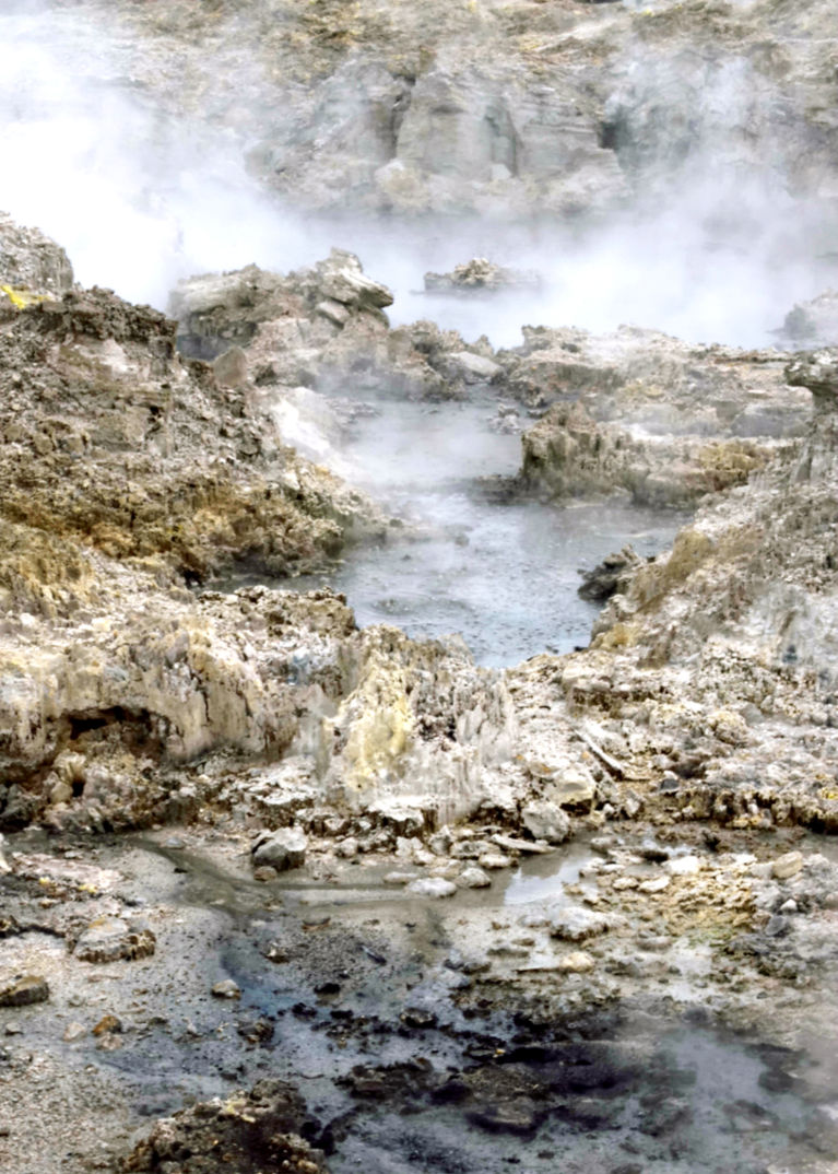 Boiling water flows from pool onto rocks below, sulphur and silica along with other crystals make the rocks very colorful
